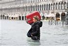 A tourist crosses flooded St. Mark’s Square in Venice, Italy, Sunday, Nov. 11, 2012. High tides have flooded Venice, leading Venetians and tourists to don high boots and use wooden walkways to cross St. Mark’s Square and other areas under water. Flooding is common this time of year and Sunday’s level that reached a peak of 150 centimeters was below the 160 centimeters recorded four years ago in the worst flooding in decades.