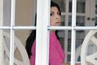 Jill Kelley looks out the window of her home Tuesday in Tampa, Fla. Kelley is identified as the woman who allegedly received harassing emails from David Petraeus' paramour, Paula Broadwell.